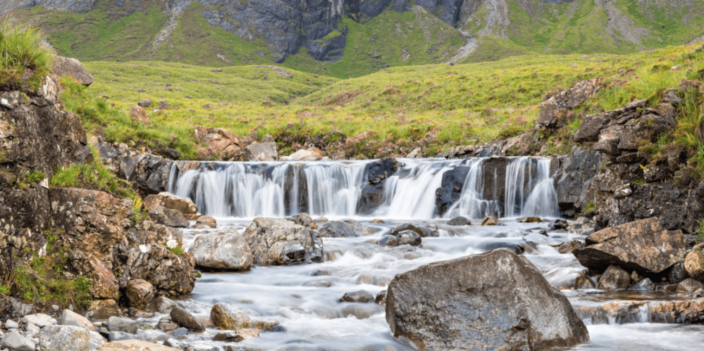 a large waterfall over a rocky cliff