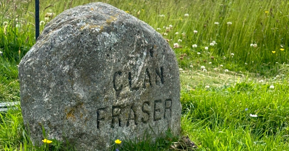 a stone building with a grassy field