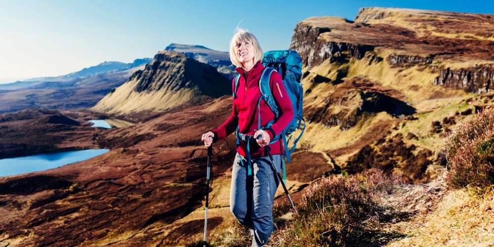 a woman standing on a rocky hill