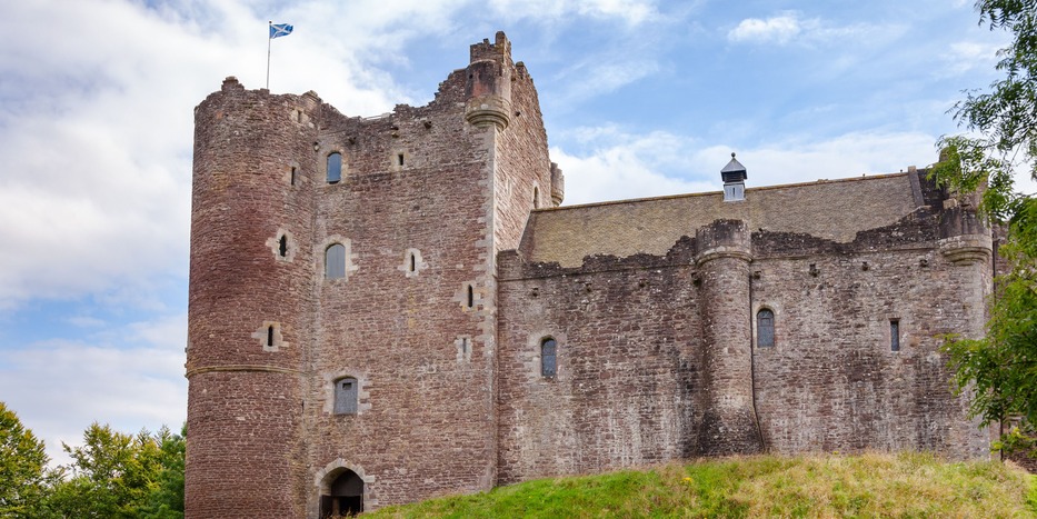 a stone castle next to a brick building