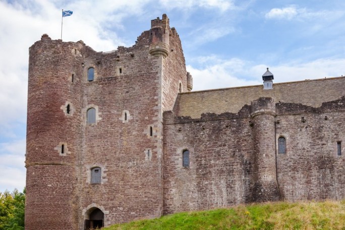 a stone castle next to a brick building